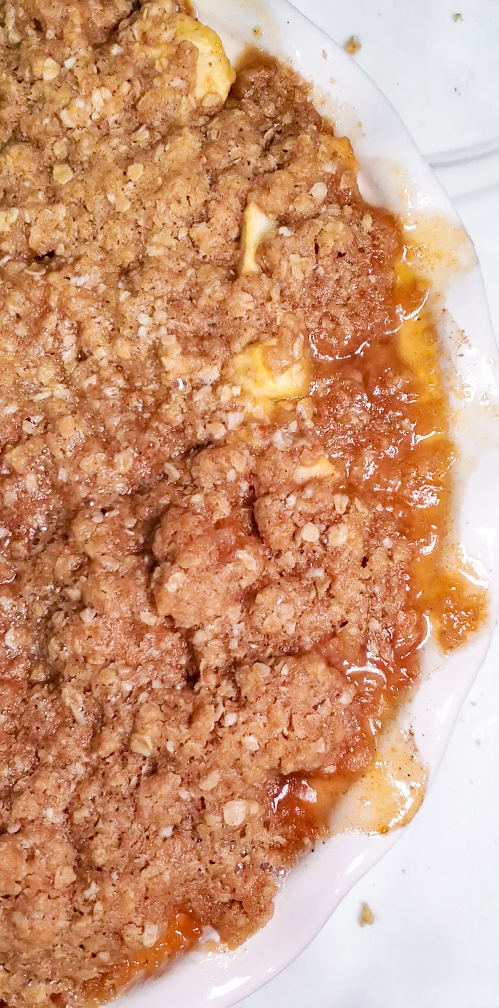 close-up of buttery oat crumble over baked cinnamon apples
